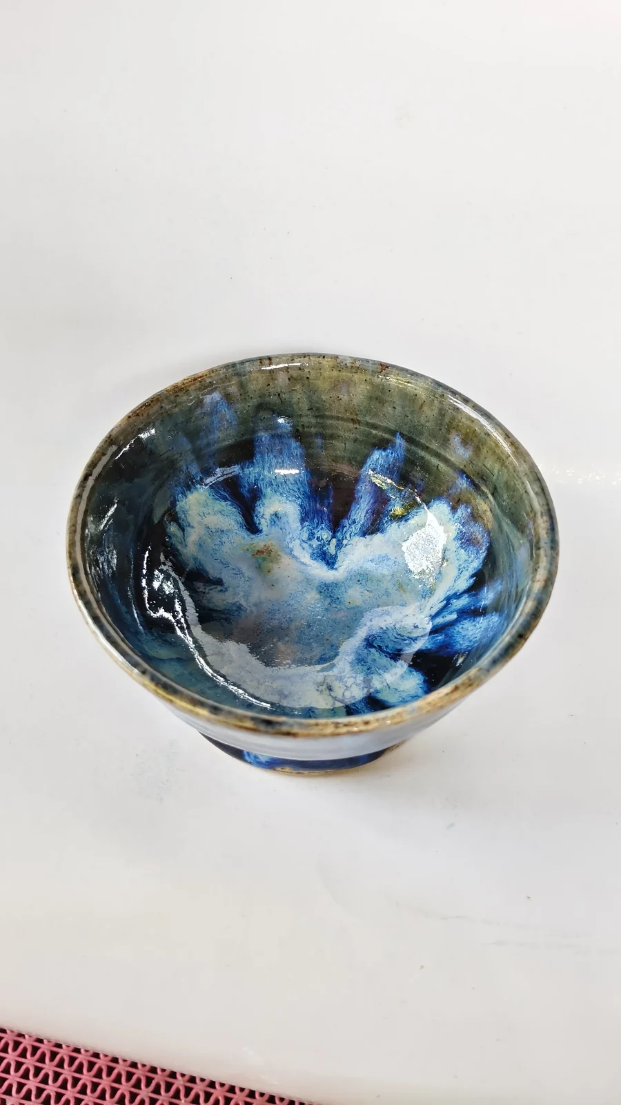 Detail bagian dalam mangkuk dengan glasir biru dan putih yang mengalir