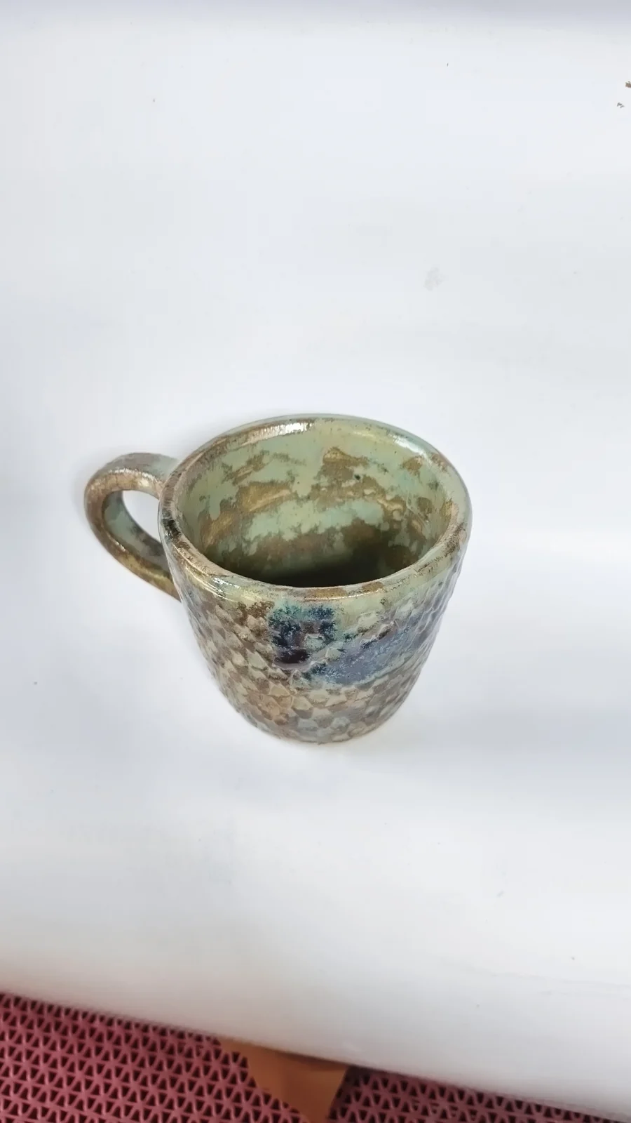 Mug hijau bertekstur dilihat dari atas, memperlihatkan bagian dalamnya