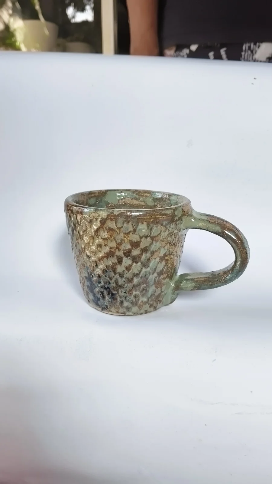 Mug hijau bertekstur dengan gagang di sebelah kanan
